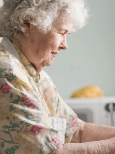 An elderly woman at the kitchen